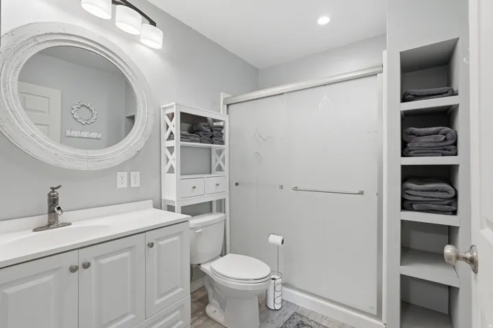 Full bathroom featuring vanity, a shower stall, and light wood-style flooring