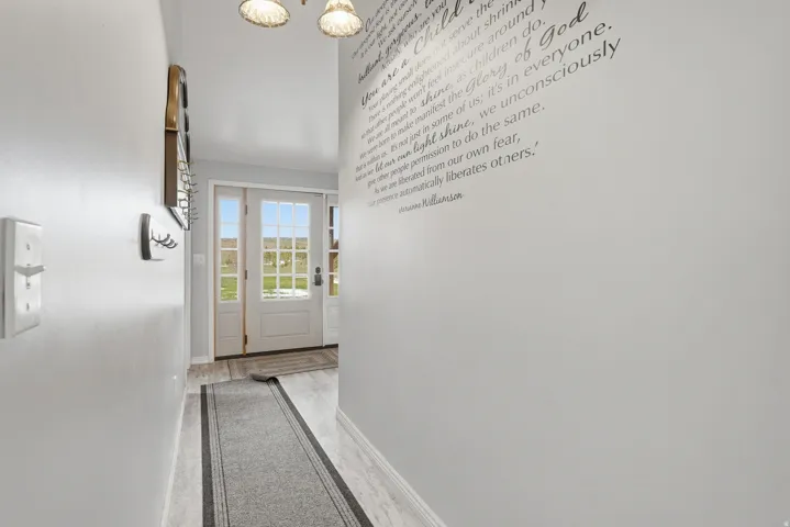 Doorway to outside featuring a chandelier and wood finished floors
