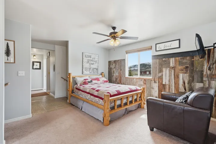 Bedroom with light colored carpet and a ceiling fan