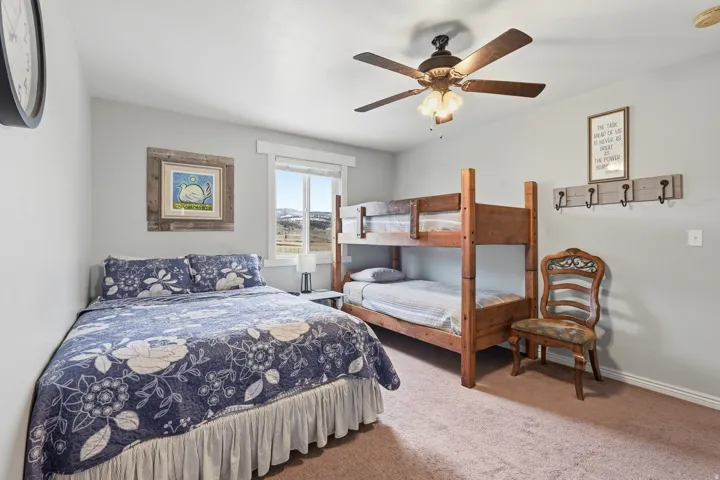 Bedroom with a ceiling fan and light colored carpet