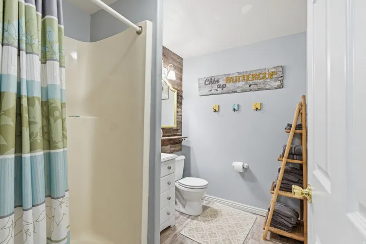 Full bath featuring a shower stall, vanity, and light wood-style flooring