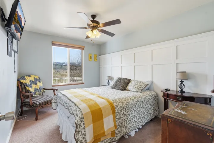 Bedroom with ceiling fan and dark carpet