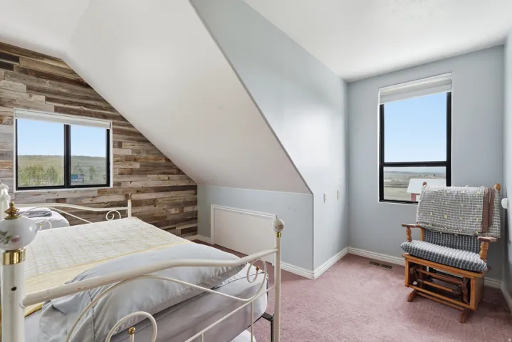 Bedroom with light carpet and vaulted ceiling
