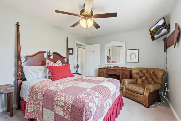 Bedroom with light colored carpet and ceiling fan