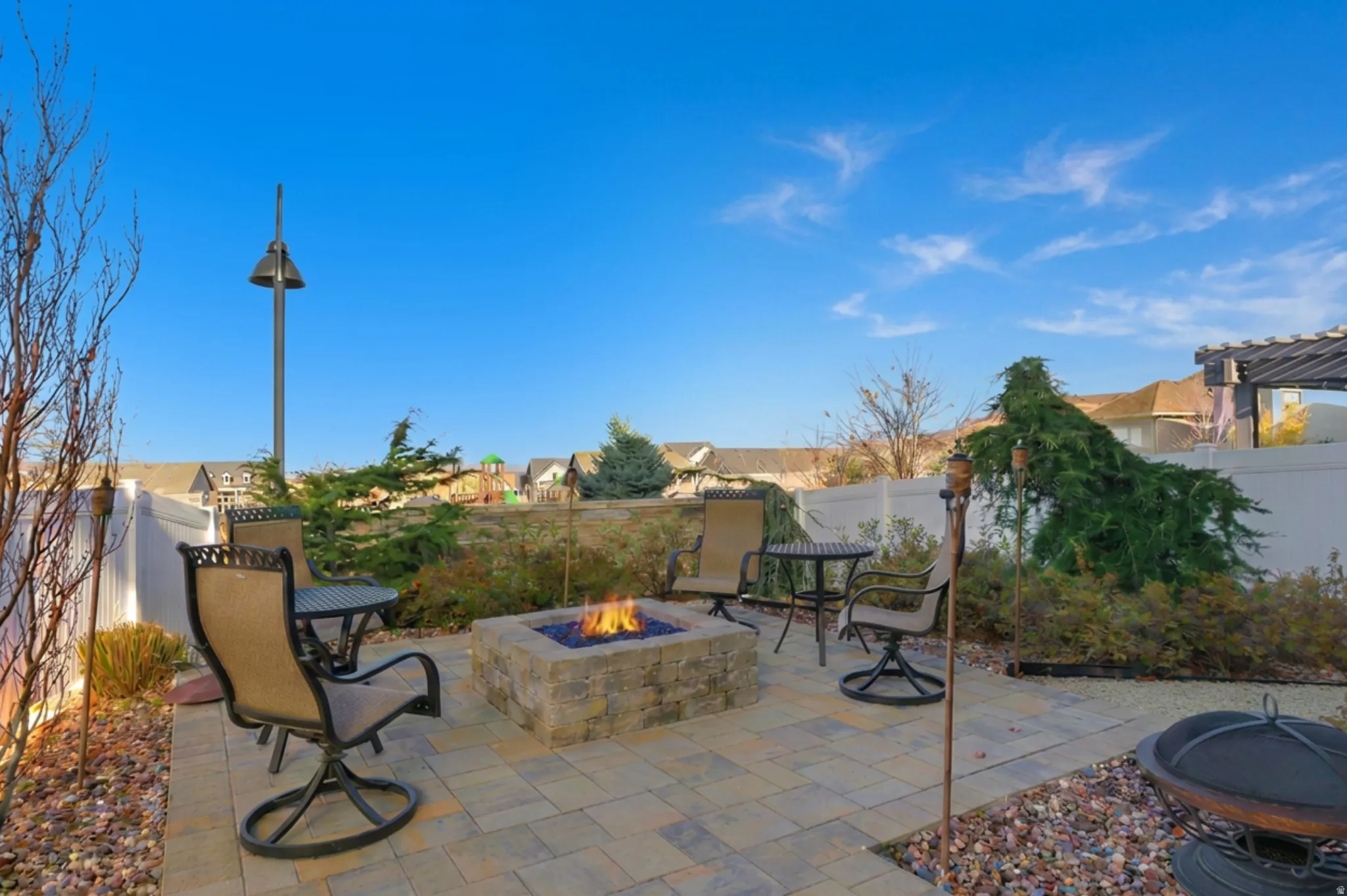 Back patio within a fenced backyard and gas fire pit