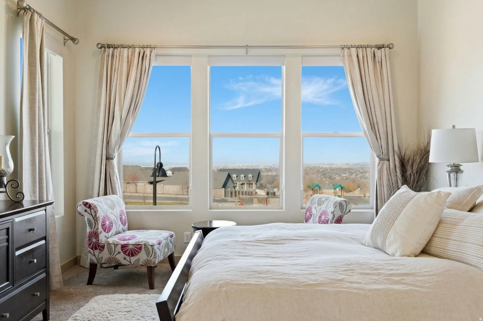 Carpeted primary bedroom featuring large windows and valley view