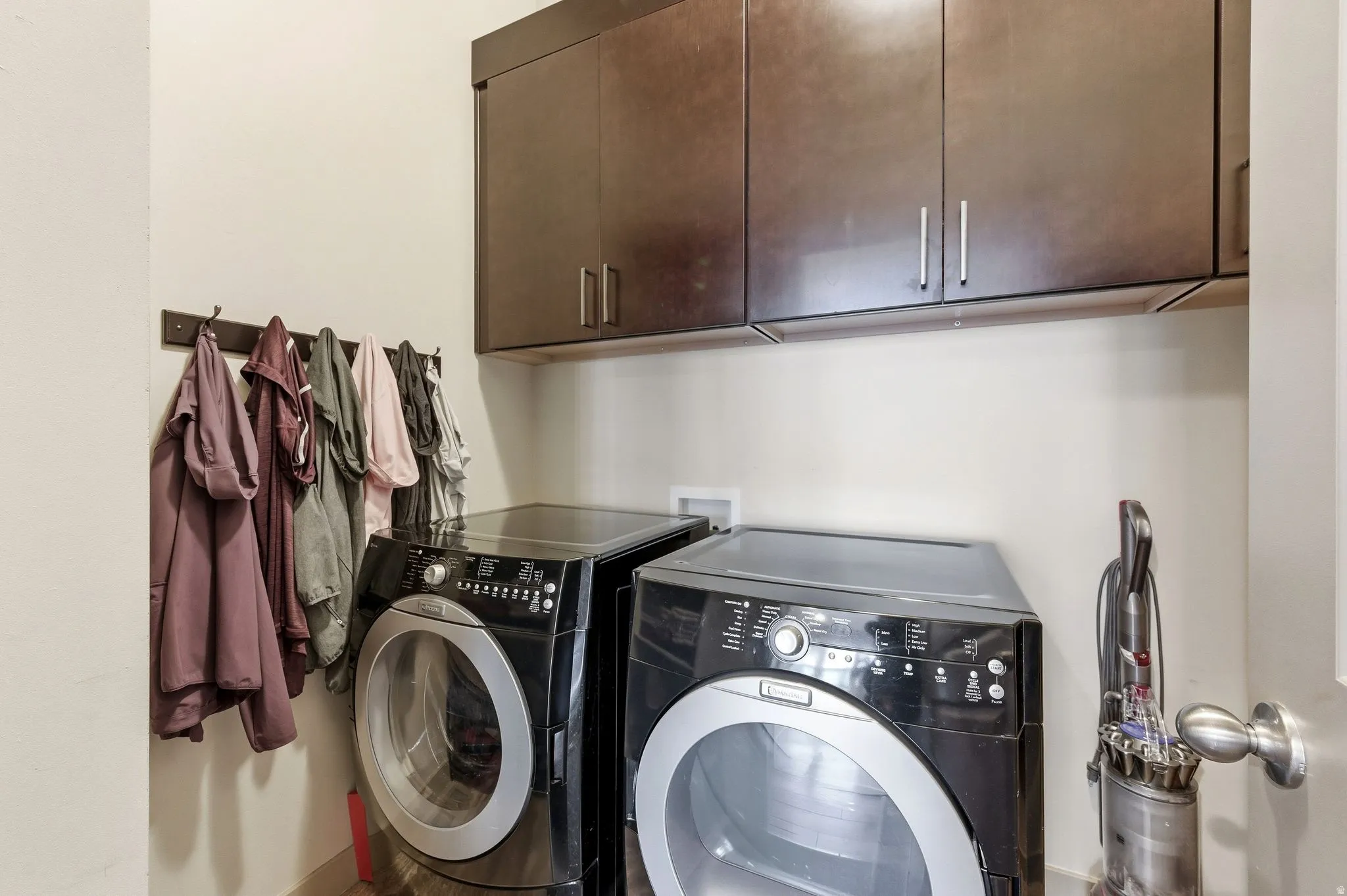 Upstairs laundry area featuring cabinet space, washer, and dryer