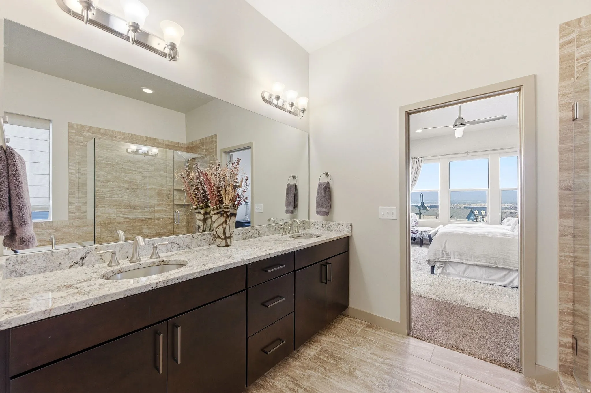 Primary ensuite bathroom featuring double vanity, a spacious closet, and separate garden tub and shower