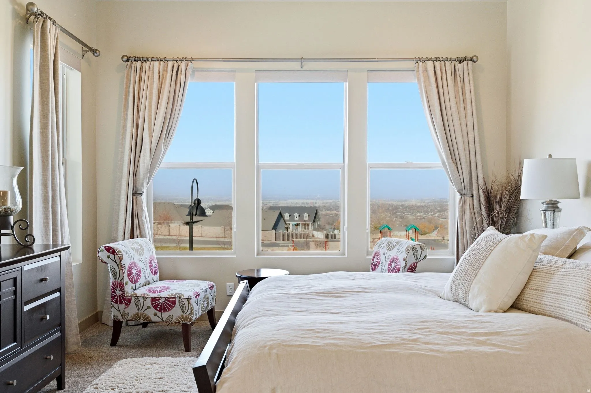 Carpeted primary bedroom featuring large windows.