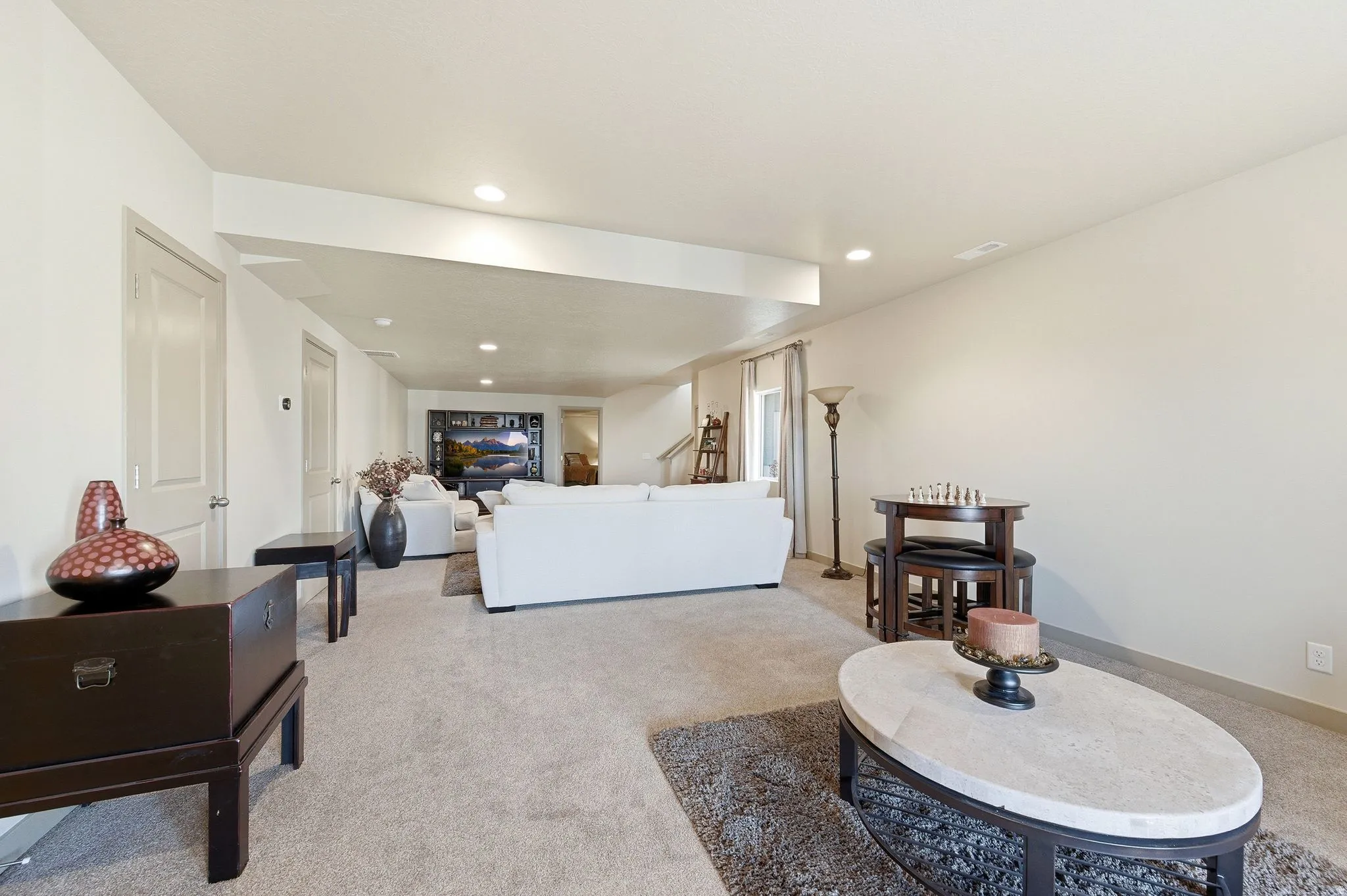 Large basement living room featuring carpet floors, a textured ceiling, and recessed lighting