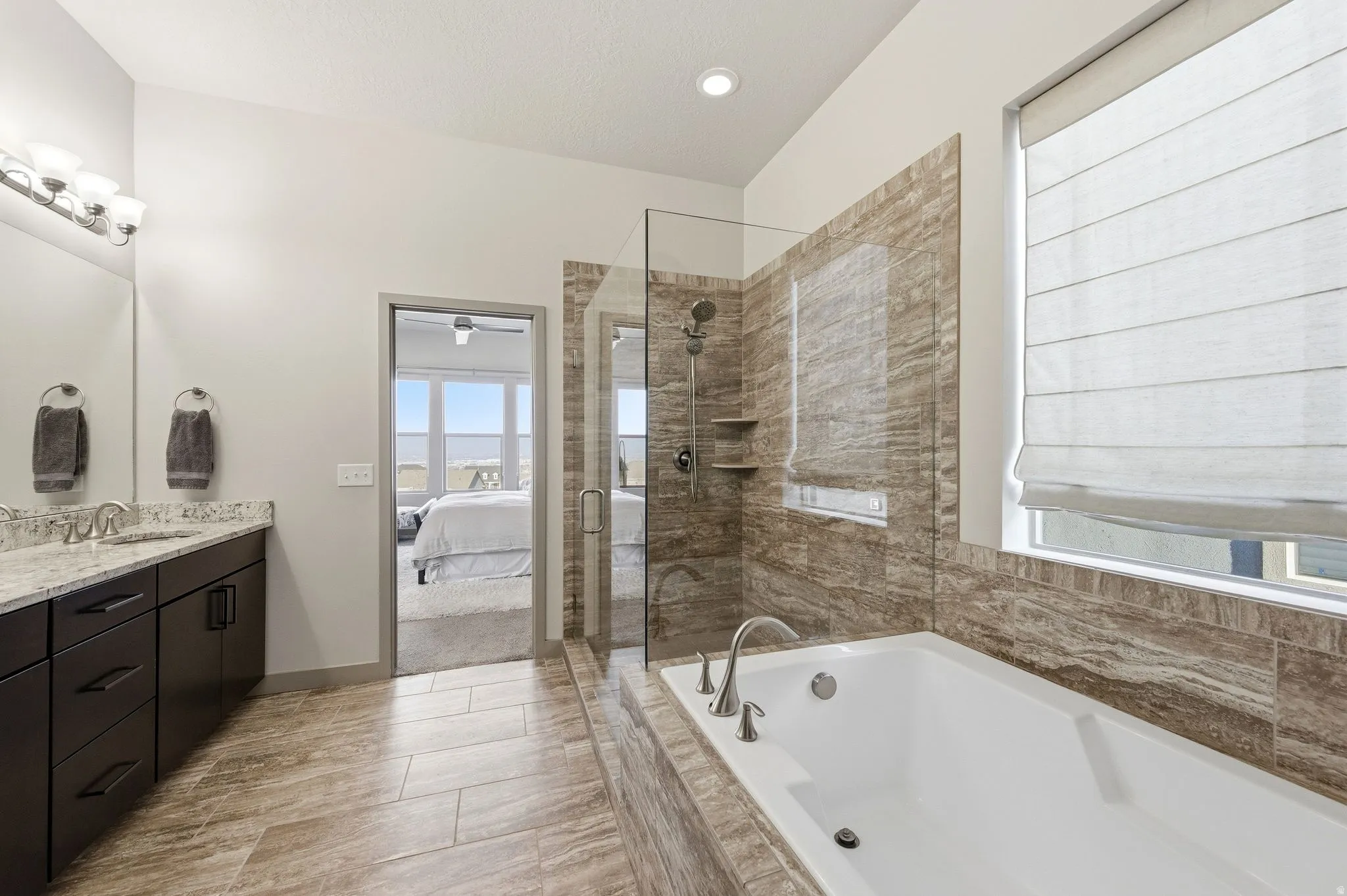 Primary ensuite bathroom featuring double vanity, and separate garden tub and shower