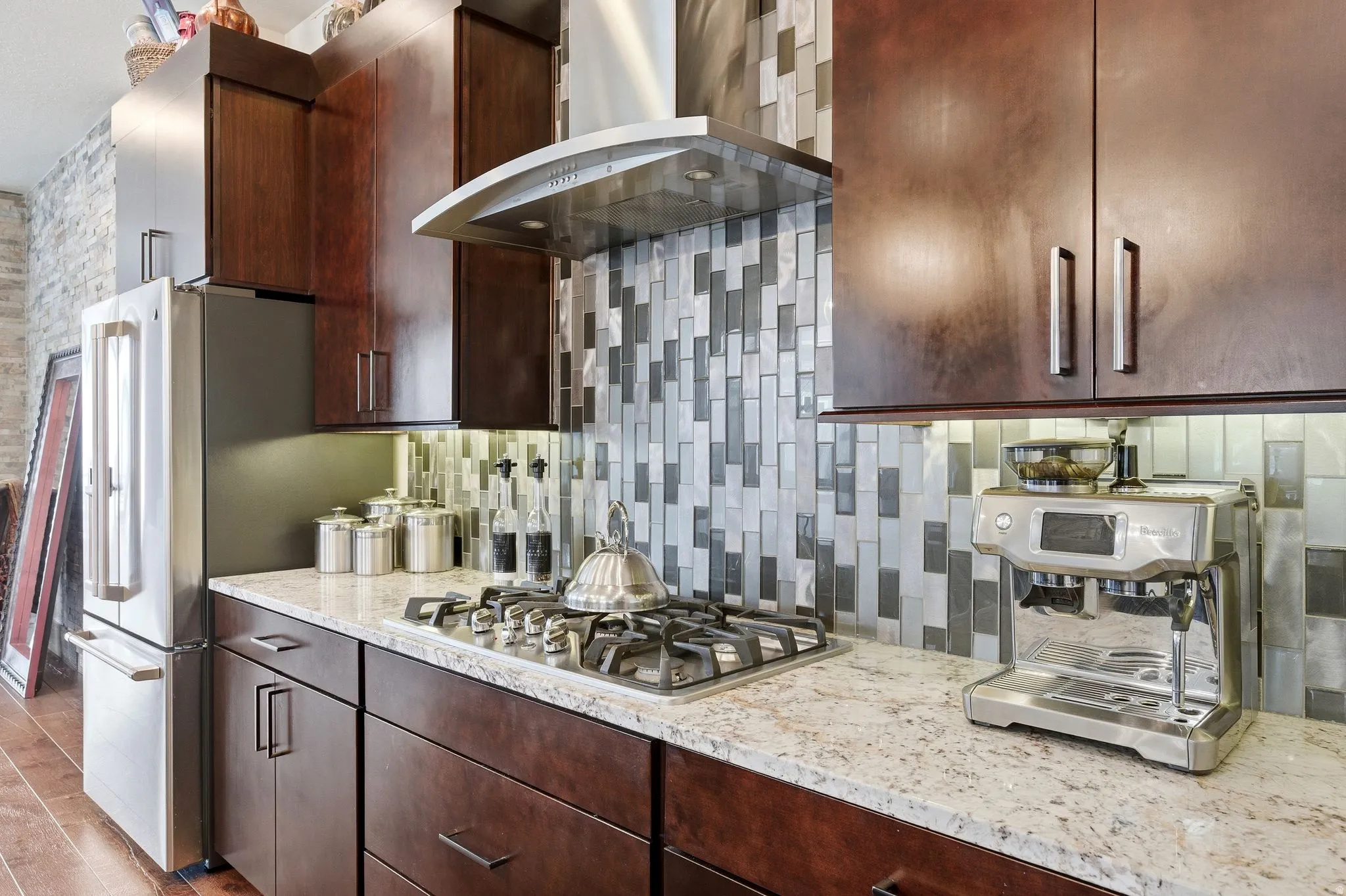 Kitchen with gas range and commercial grade hood.