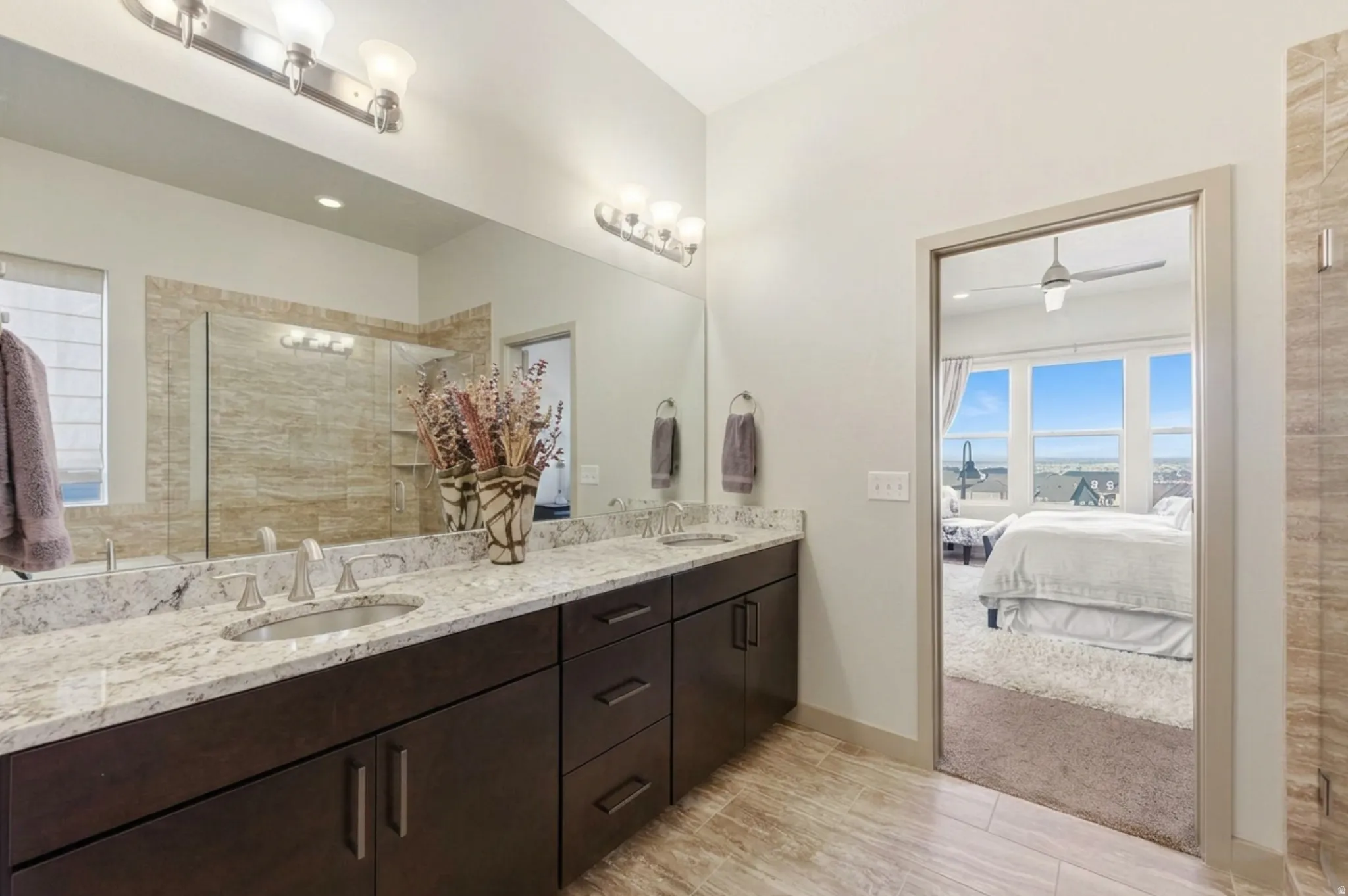 Primary ensuite bathroom featuring double vanity, a spacious closet, and separate garden tub and shower