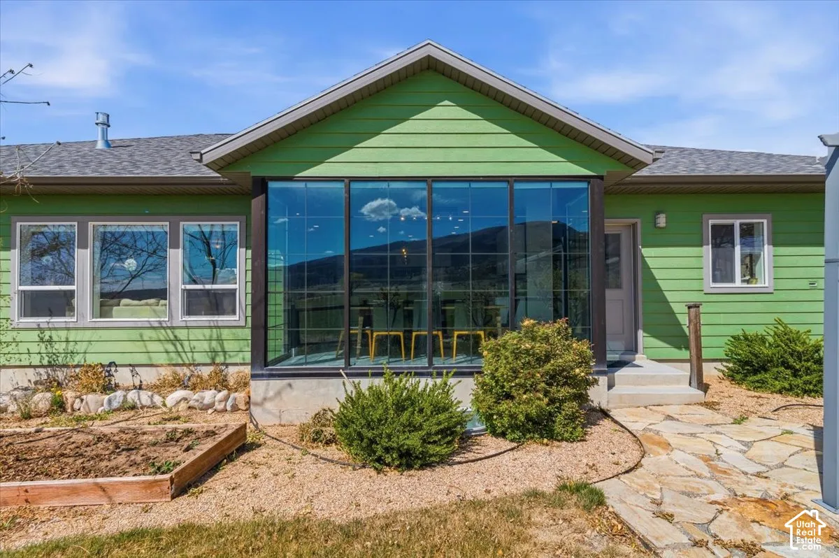 Rear view of property featuring roof with shingles