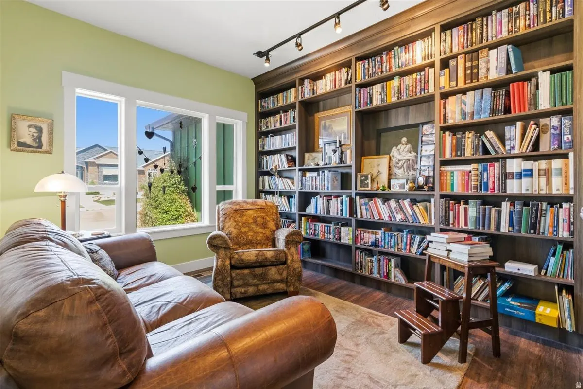 Sitting room featuring track lighting, light wood finished floors, and bookshelves