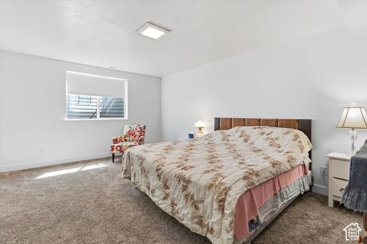 Bedroom featuring dark colored carpet