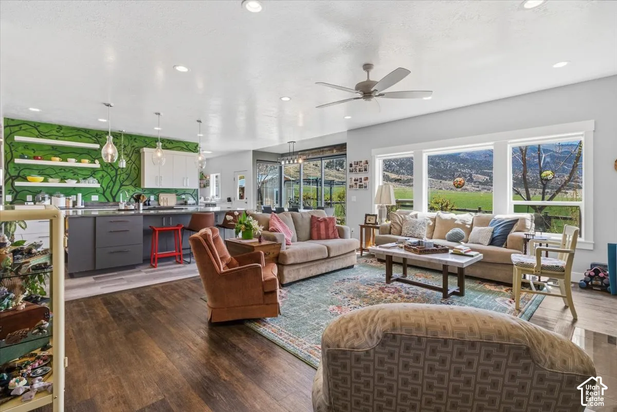 Living area with dark wood-style floors, a ceiling fan, and recessed lighting