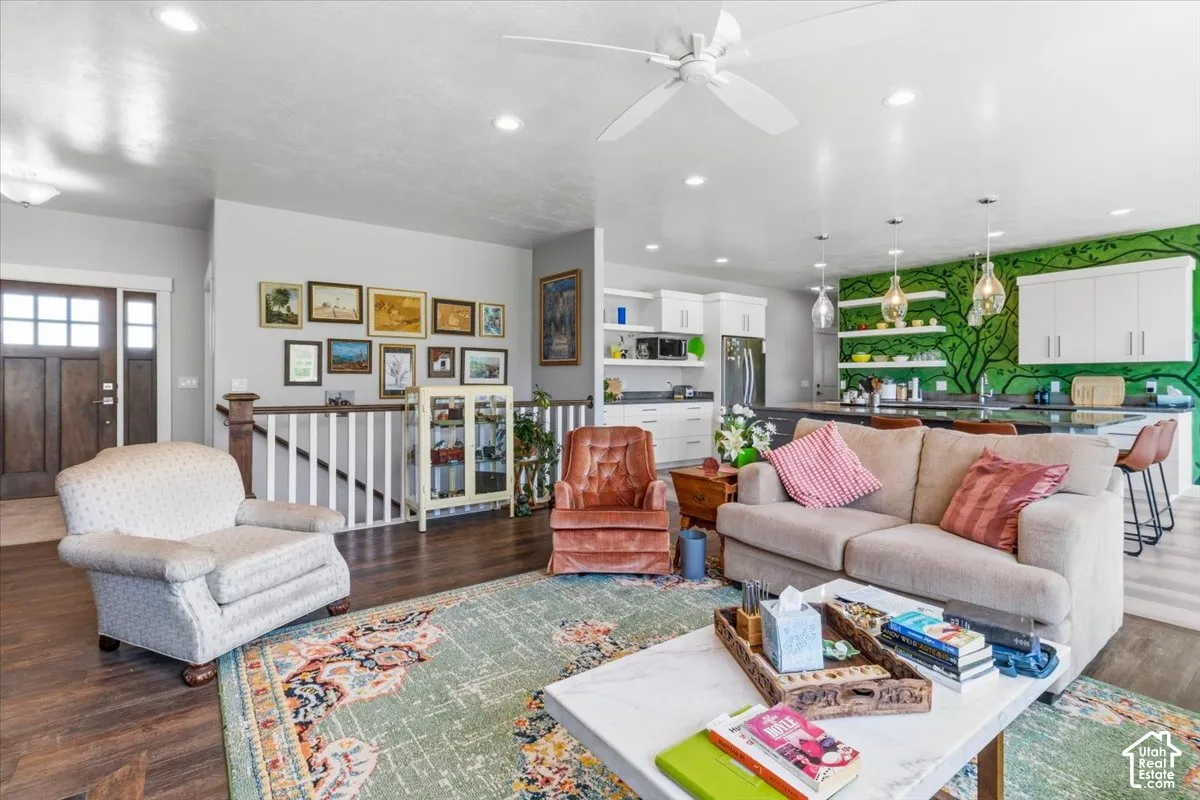 Living room featuring dark wood-type flooring, recessed lighting, and ceiling fan
