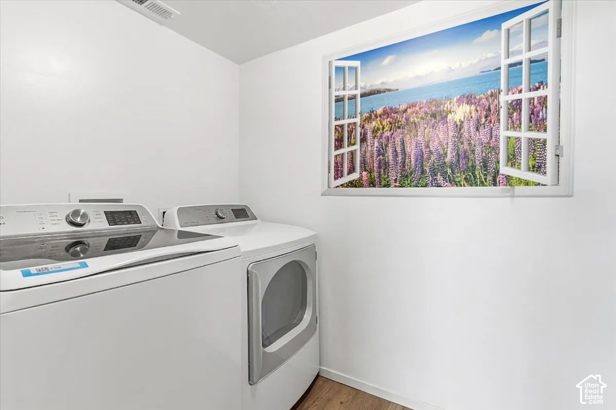 Laundry room featuring light wood-type flooring, independent washer and dryer