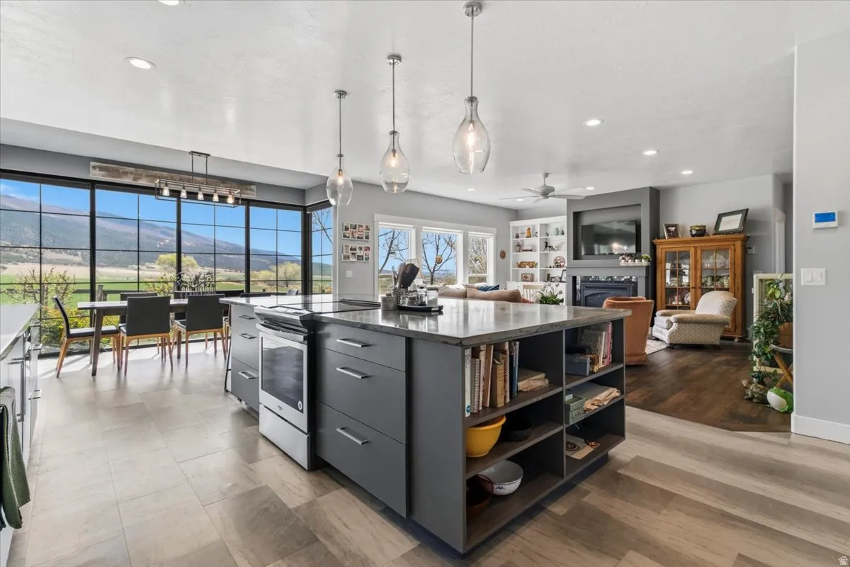 Kitchen featuring stainless steel electric range, a mountain view, pendant lighting, a center island, and modern cabinets