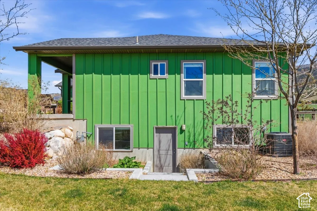 Back of property featuring board and batten siding and roof with shingles