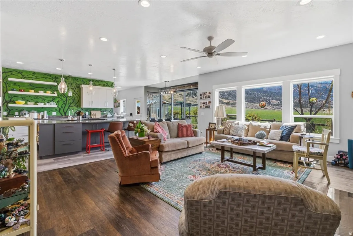 Living area with dark wood-style floors, a ceiling fan, and recessed lighting