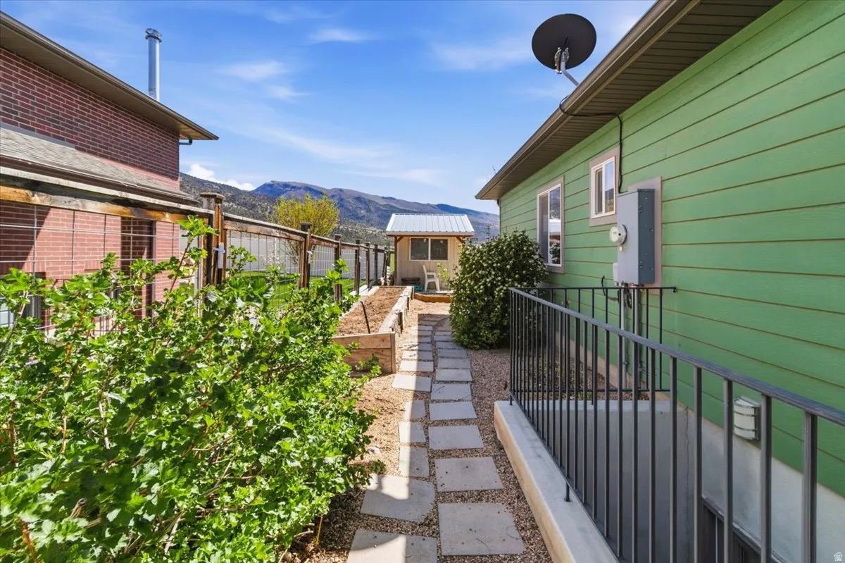 View of yard with a garden, a mountain view, and an outbuilding