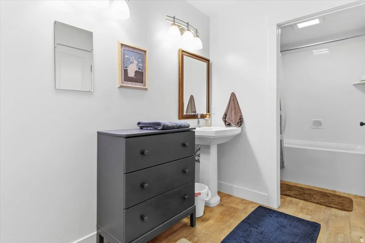 Full bath featuring light wood-style flooring and shower / bathtub combination