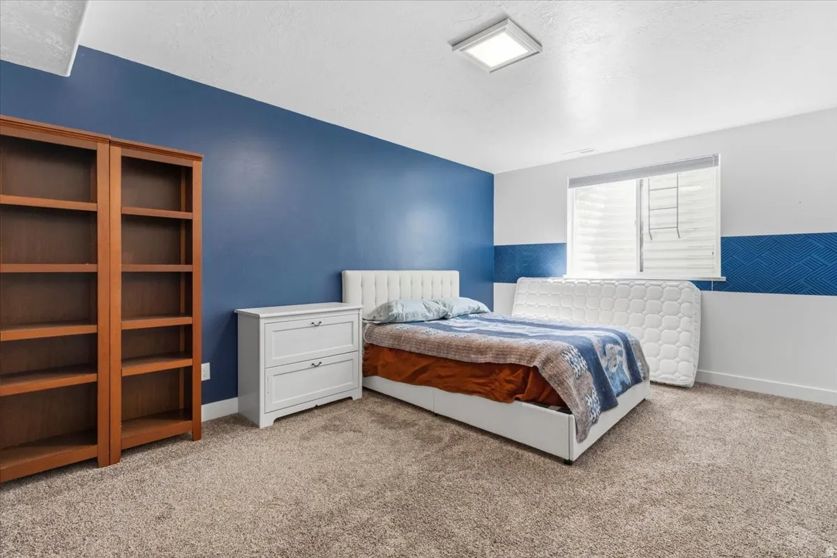 Bedroom with light carpet and a textured ceiling
