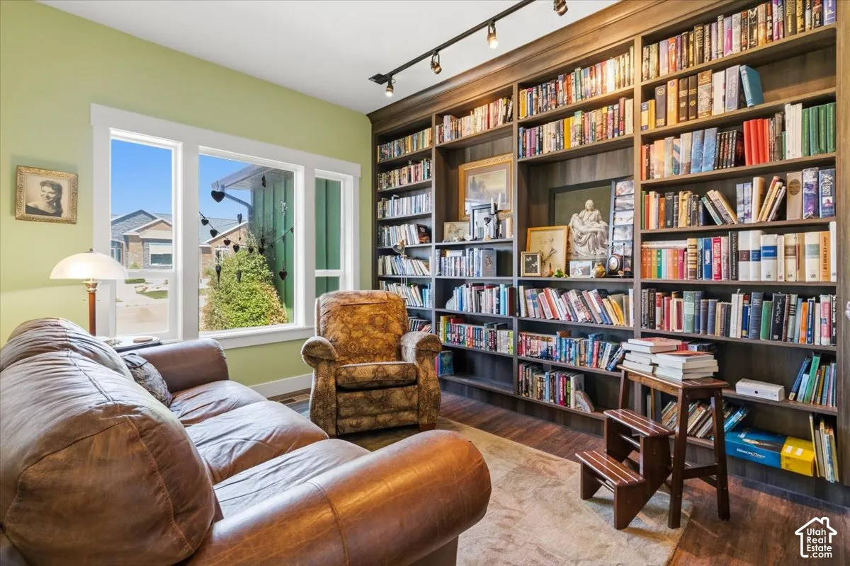 Sitting room featuring track lighting, light wood finished floors, and bookshelves