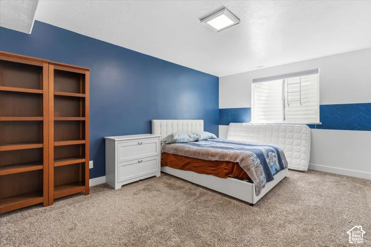 Bedroom with light carpet and a textured ceiling