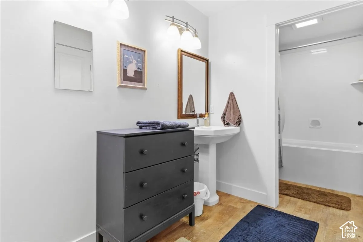 Full bath featuring light wood-style flooring and shower / bathtub combination