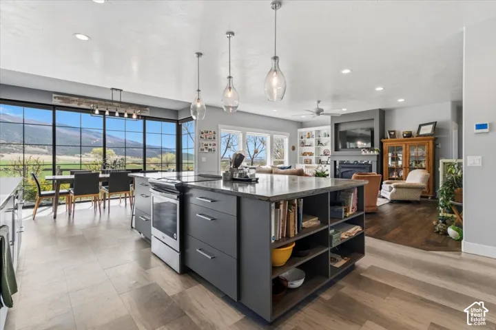 Kitchen featuring stainless steel electric range, a mountain view, pendant lighting, a center island, and modern cabinets