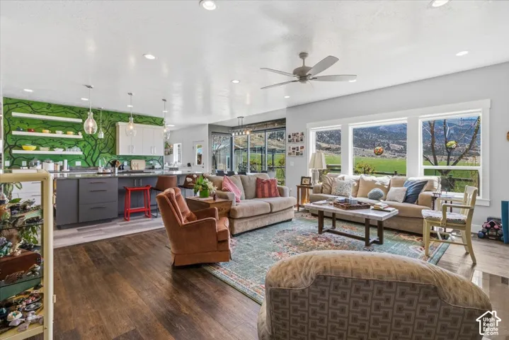 Living area with dark wood-style floors, a ceiling fan, and recessed lighting