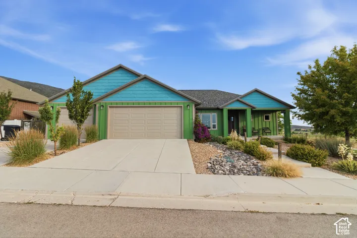 Contemporary single-story residence featuring a two-car garage, a covered front entry, and a gravel and rock landscaping design