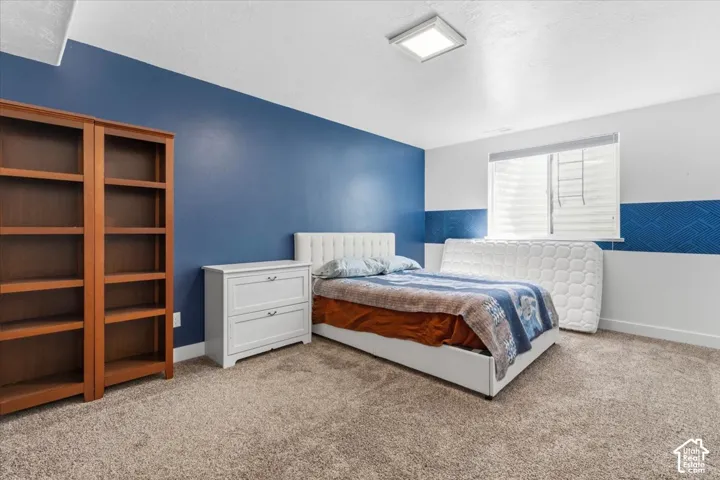 Bedroom with light carpet and a textured ceiling