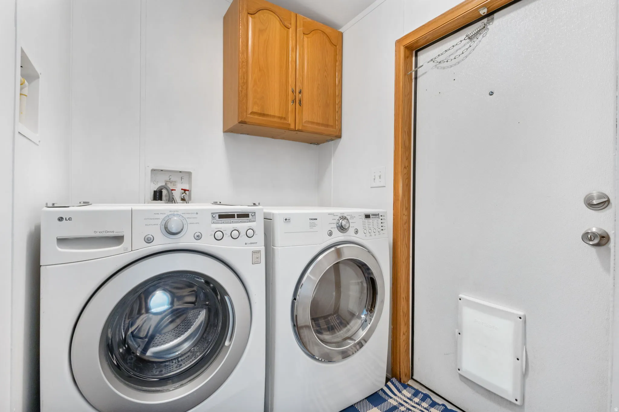 Laundry area featuring washing machine and clothes dryer and cabinet space