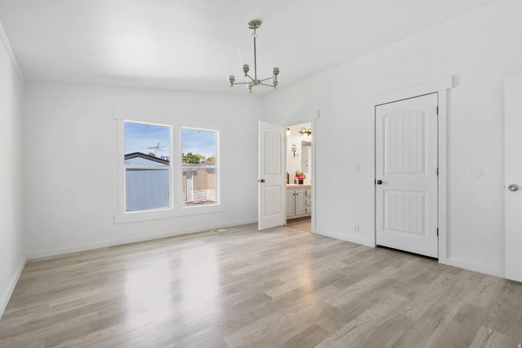 Unfurnished dining area with hanging lights, light wood-type flooring, and lofted ceiling