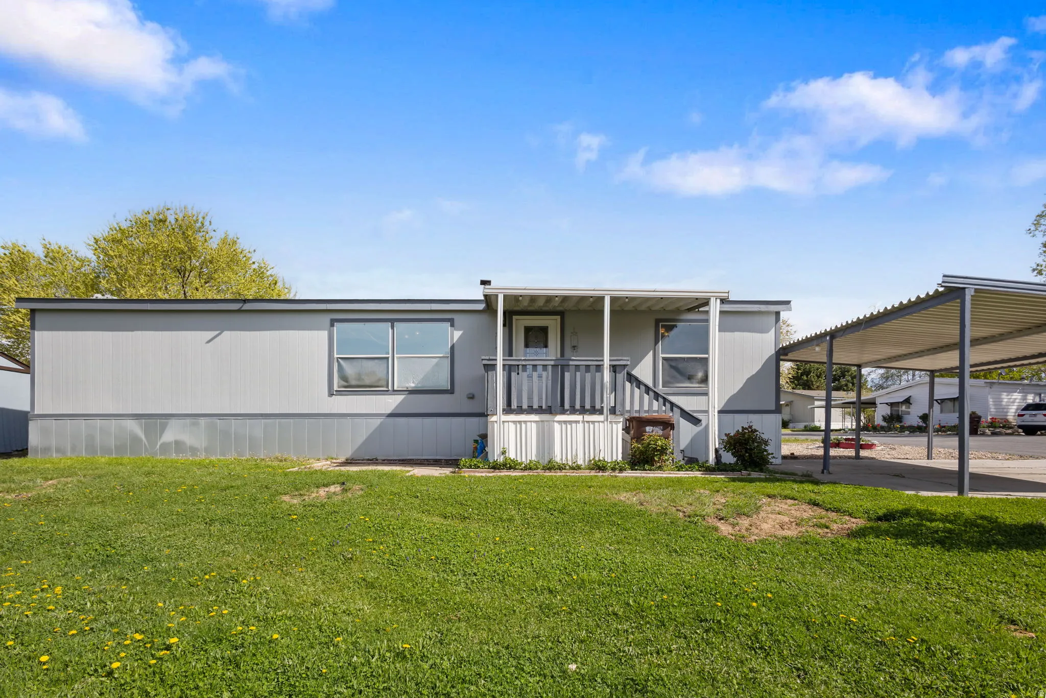 Manufactured / mobile home featuring a porch and a front yard