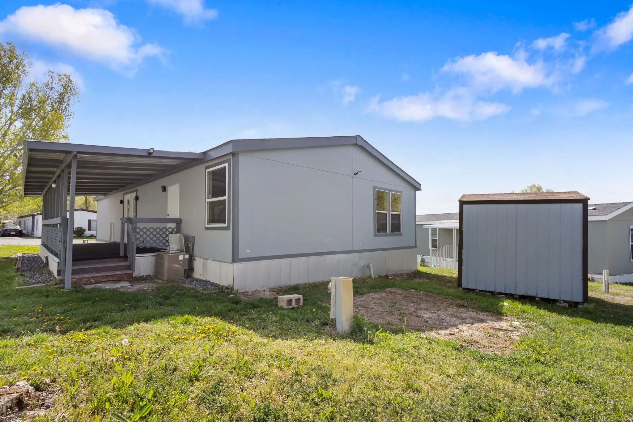 View of side of property featuring a shed and a yard