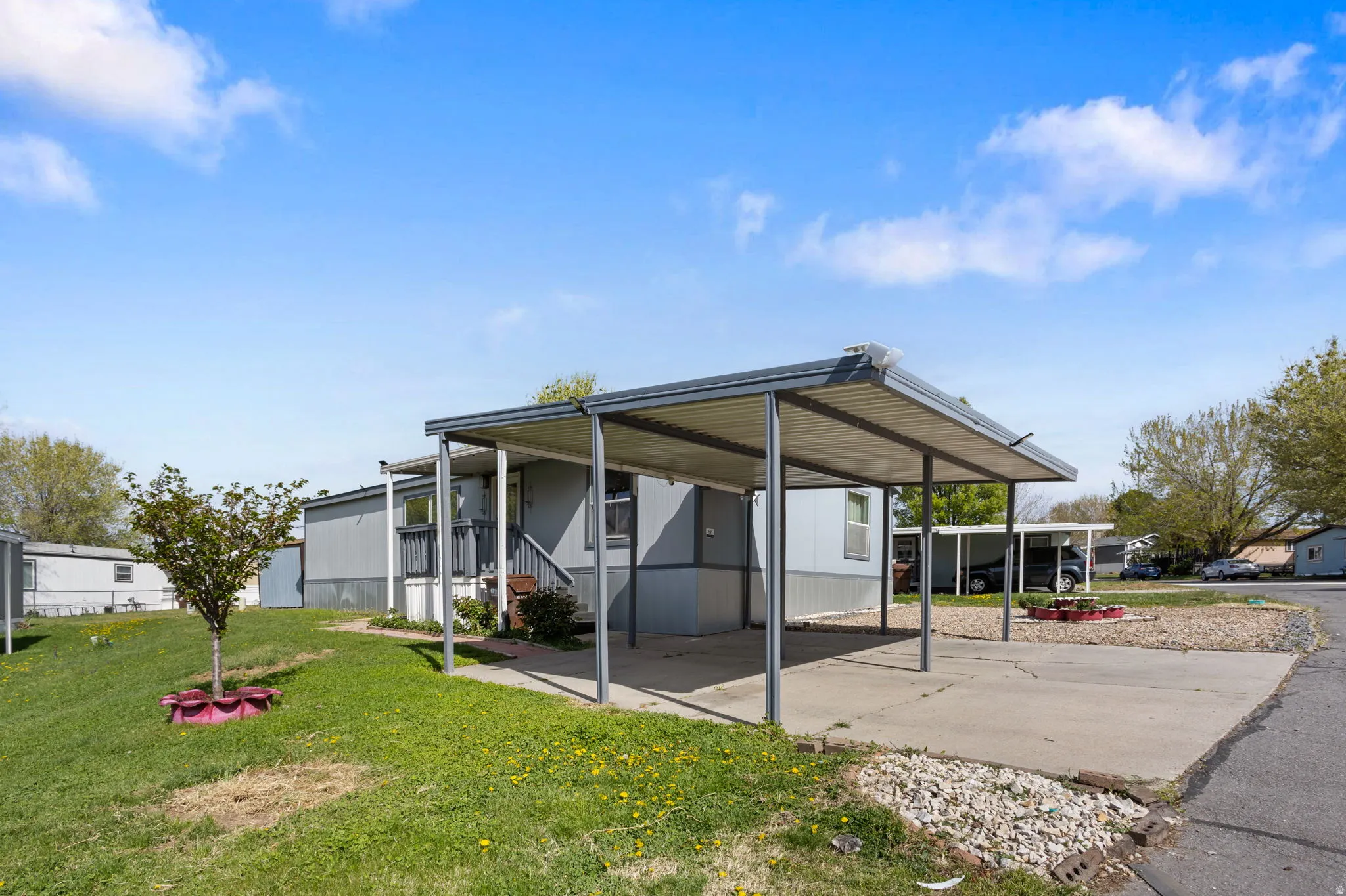 Rear view of house with a lawn and concrete driveway