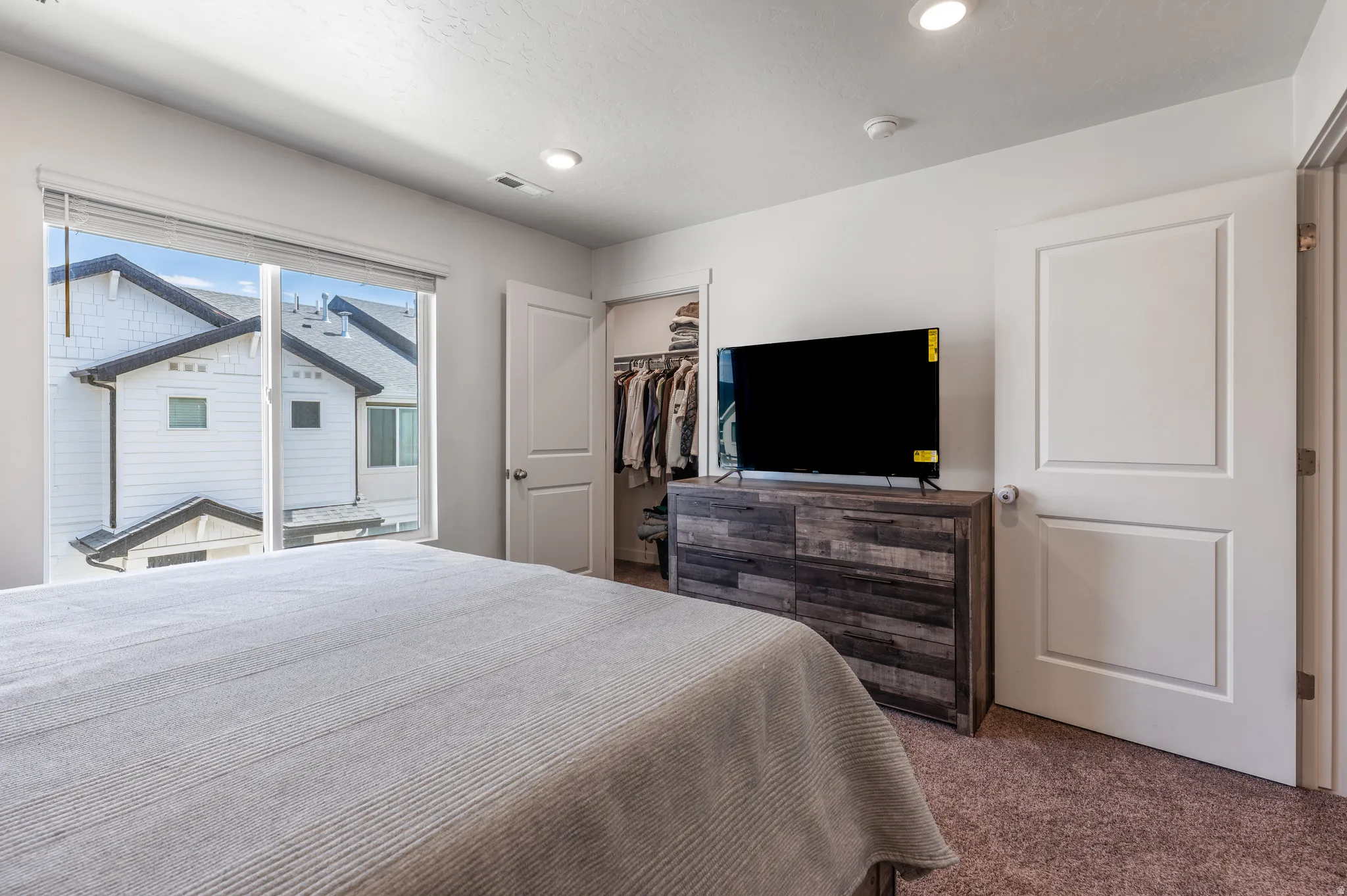 Carpeted bedroom featuring a walk in closet
