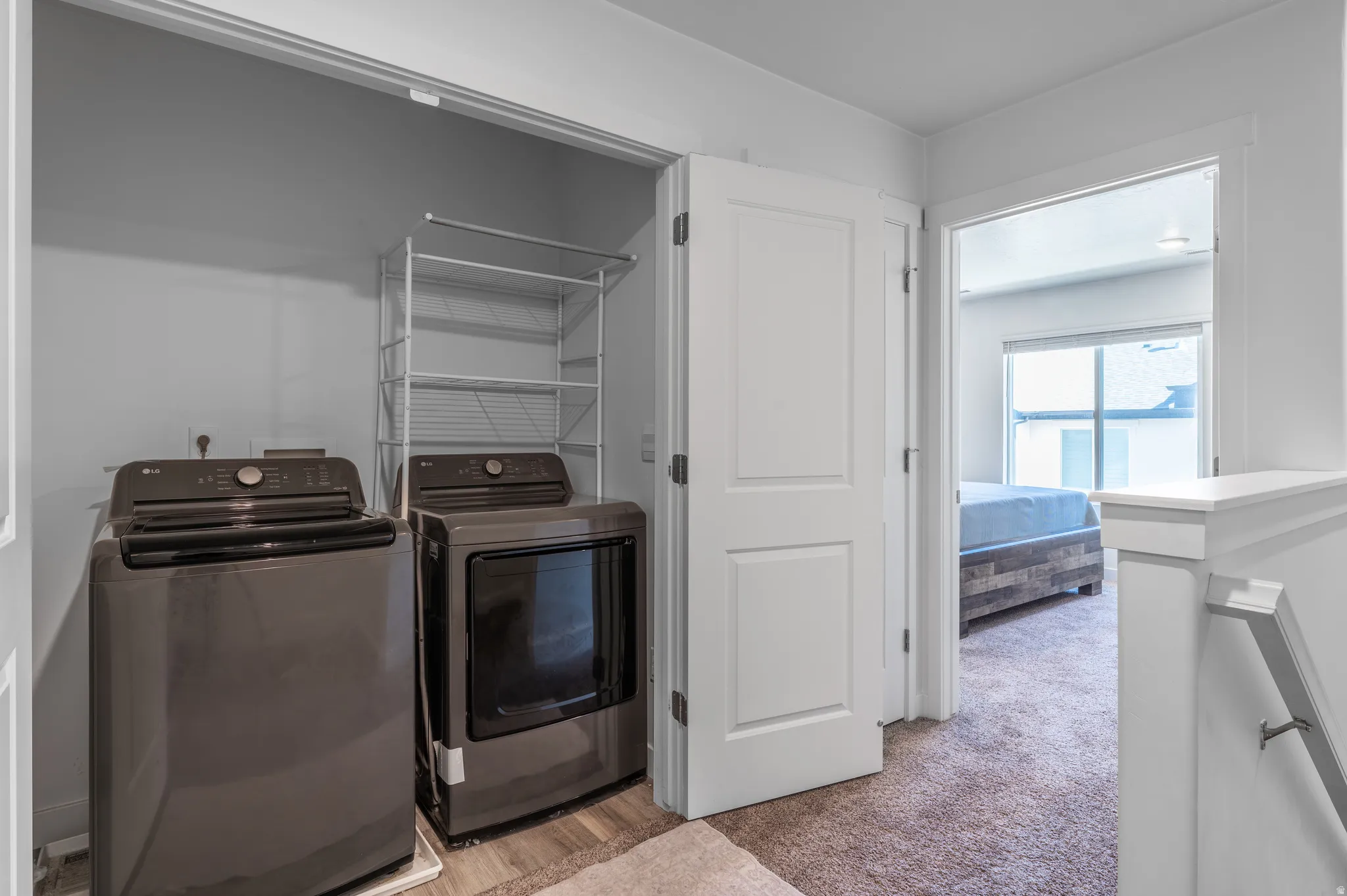 Laundry area with separate washer and dryer and light carpet