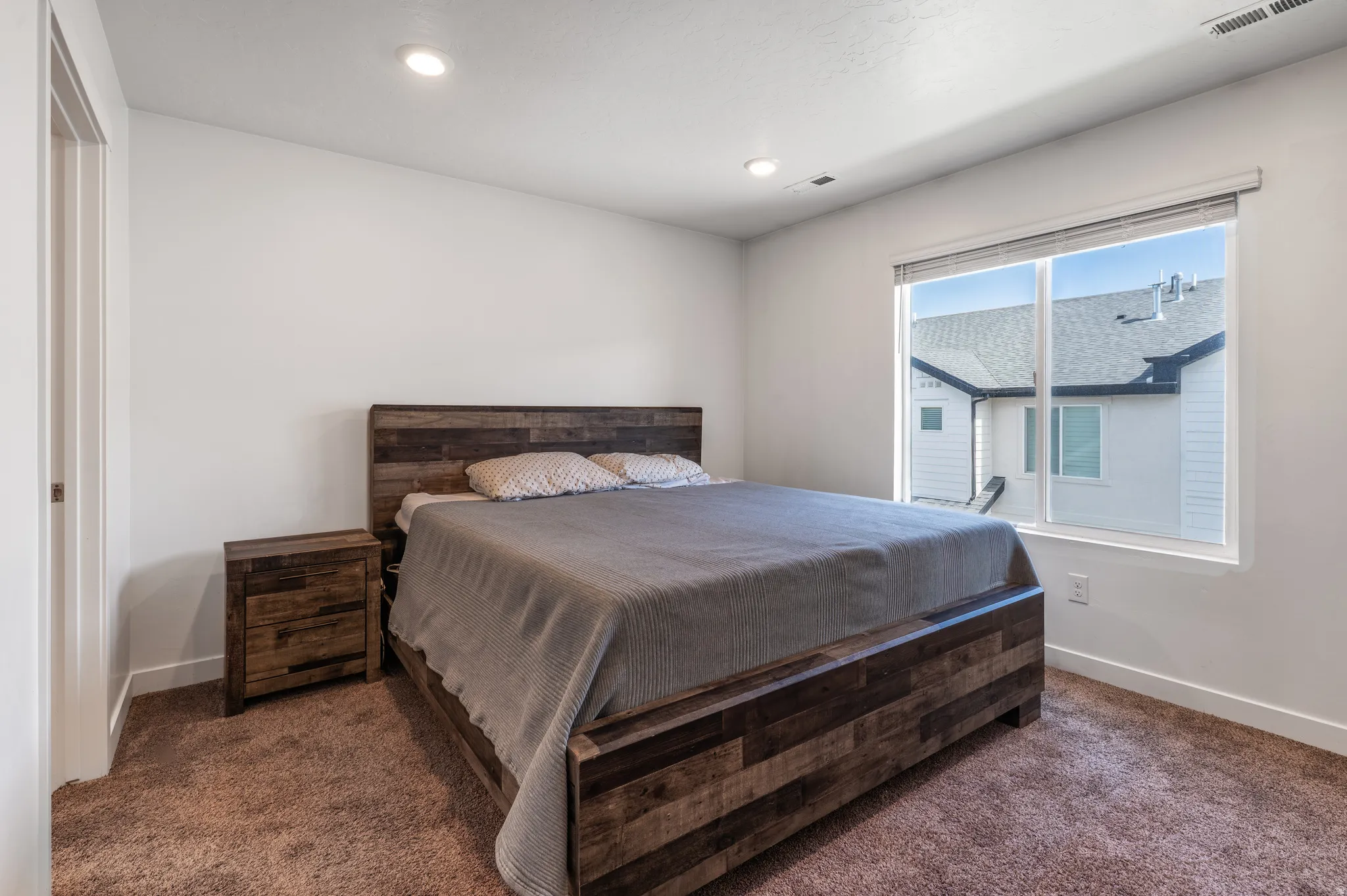 Bedroom with dark colored carpet and recessed lighting