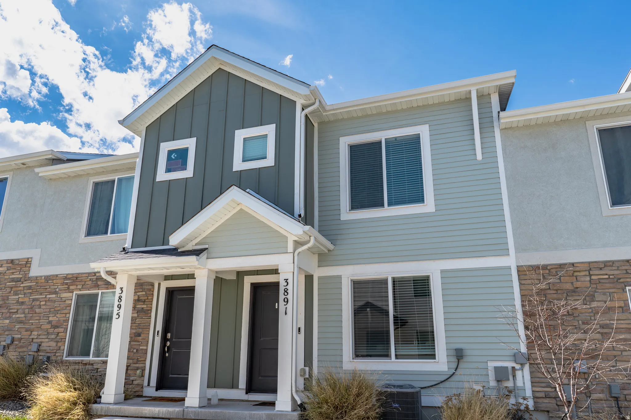View of front of property featuring stone siding and board and batten siding