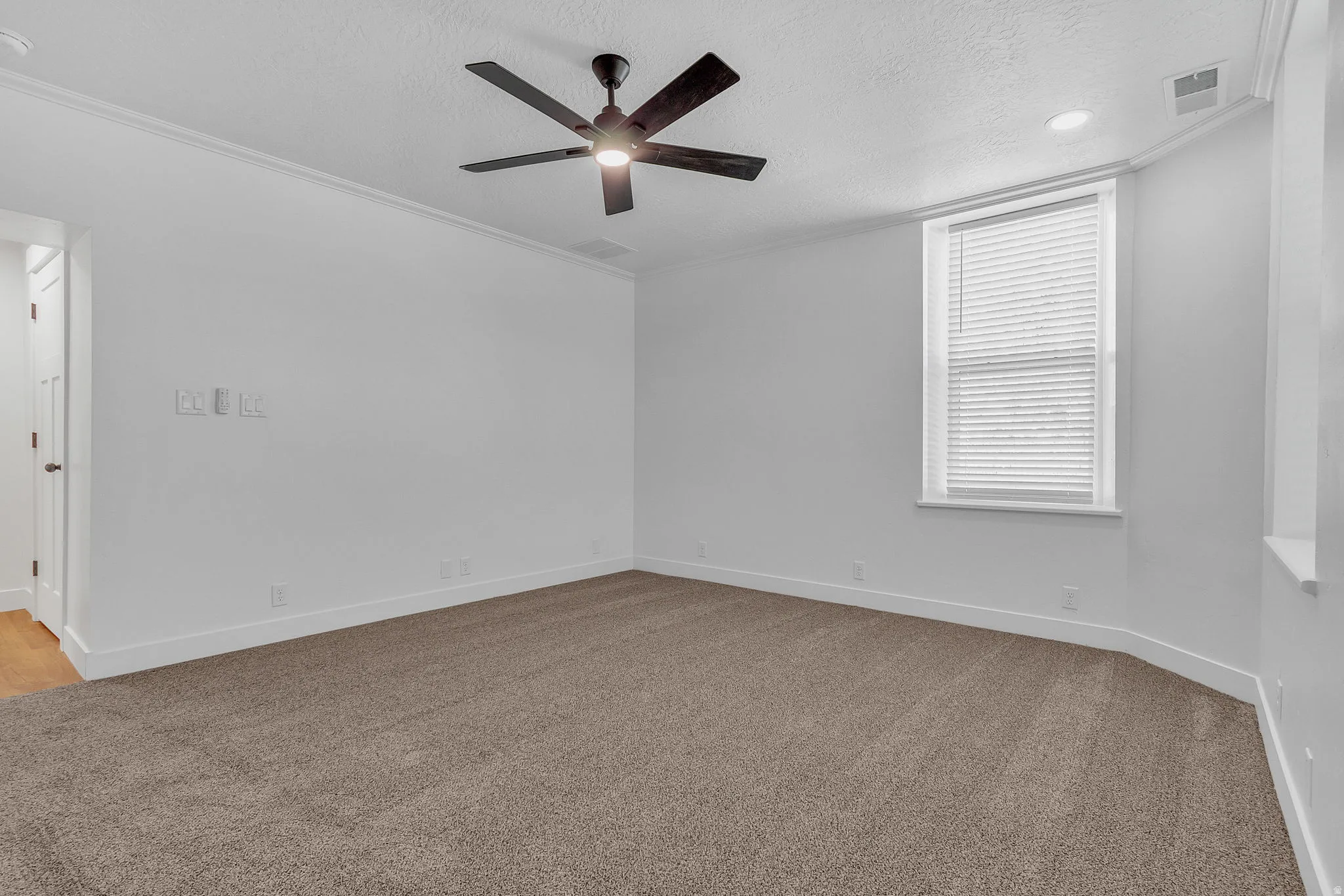Master bedroom featuring light carpet, ornamental molding, ceiling fan, a textured ceiling, and recessed lighting