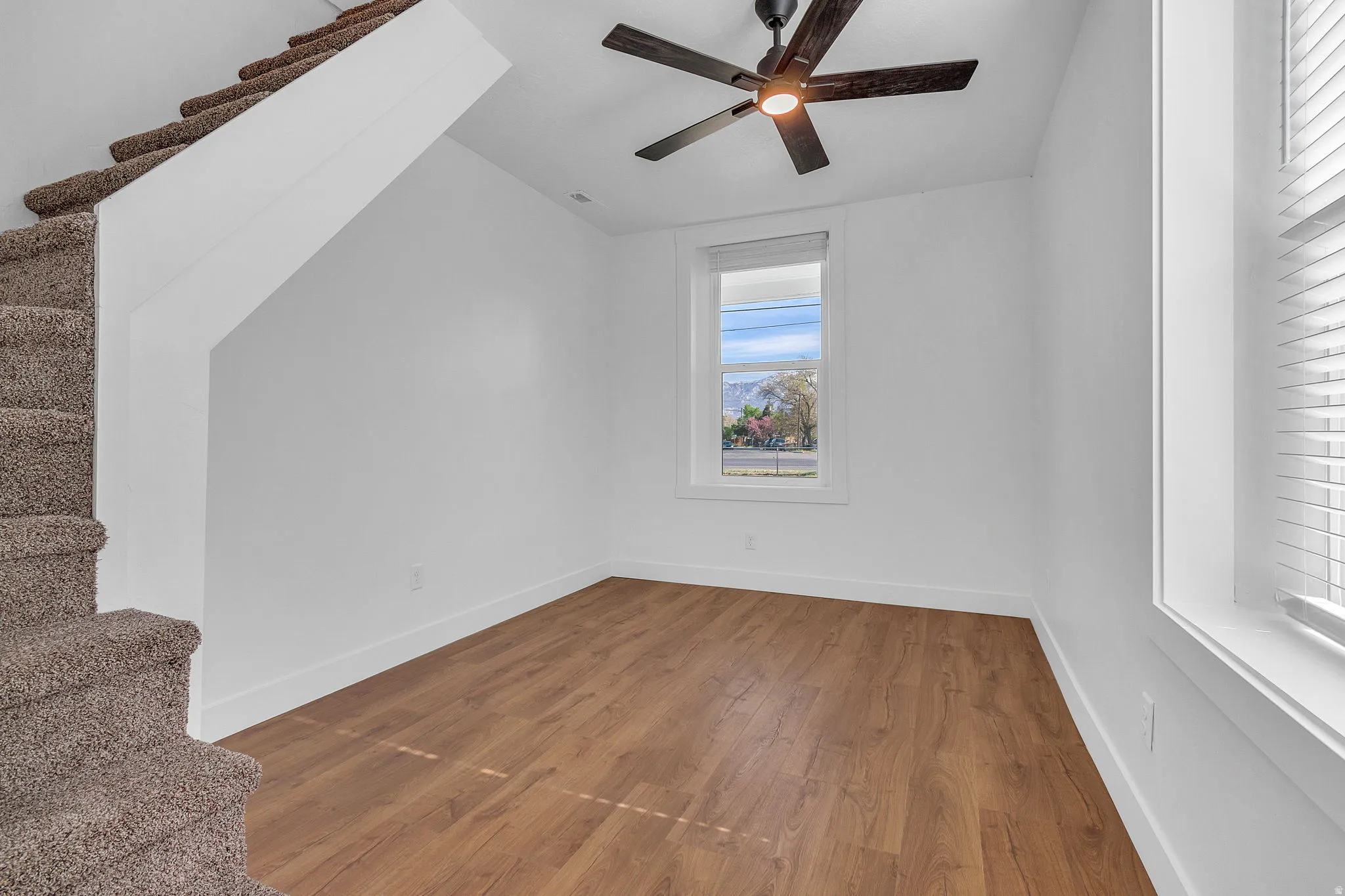 Additional living space with hardwood / wood LVP floors and ceiling fan