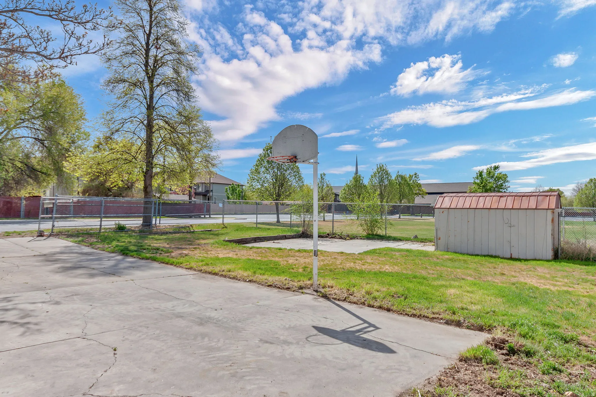 View of home's community featuring community basketball court and a shed