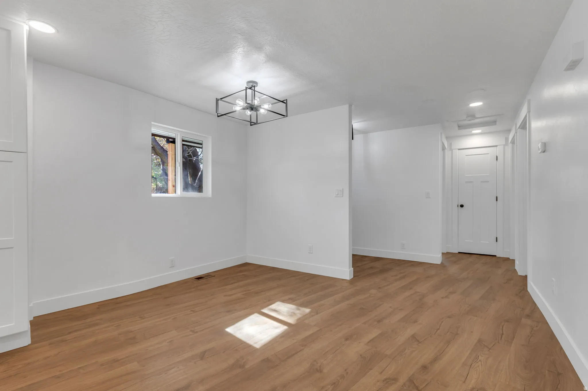 Dining area with light wood LVP flooring and a chandelier