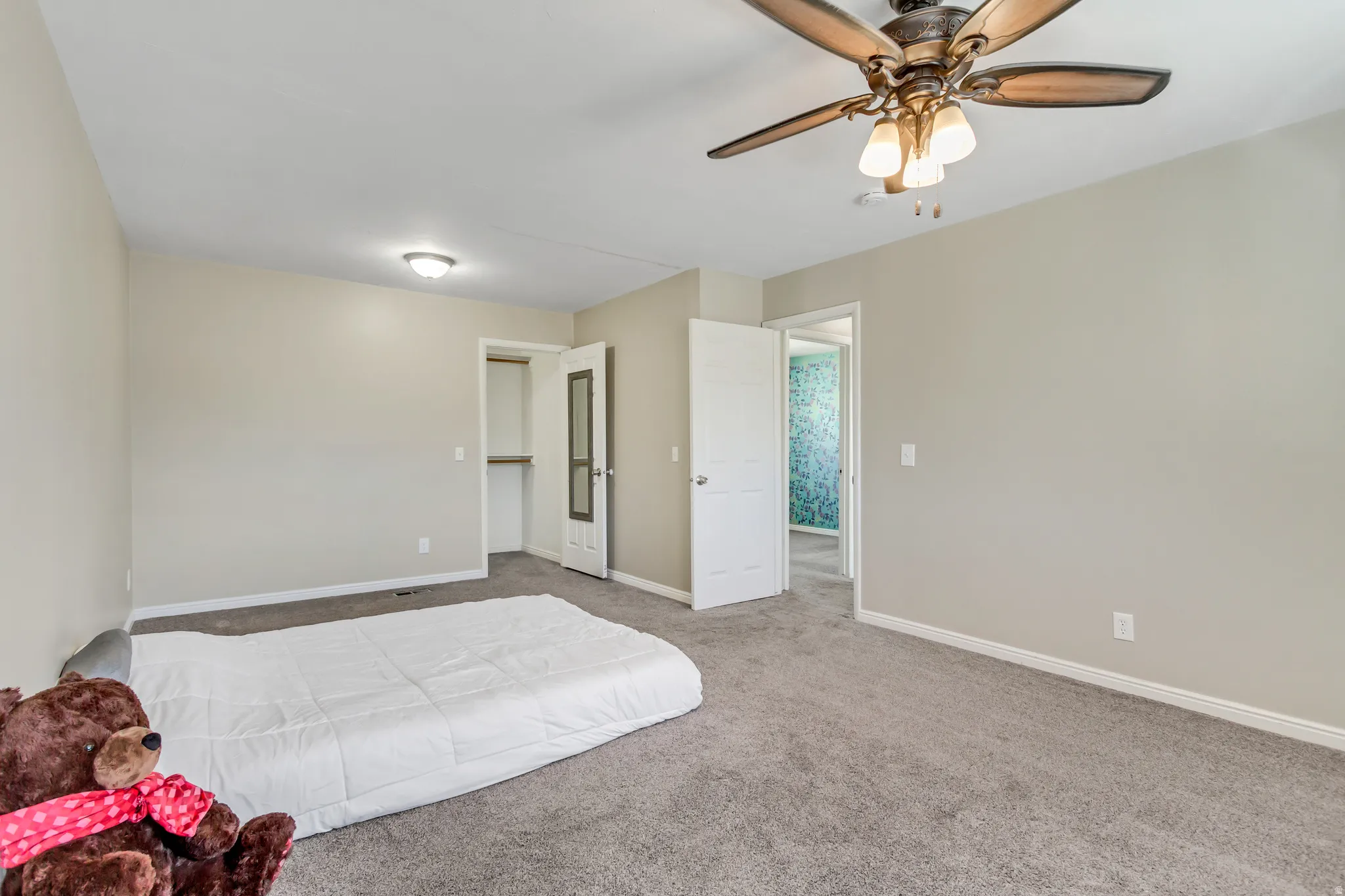 Bedroom featuring light colored carpet and ceiling fan